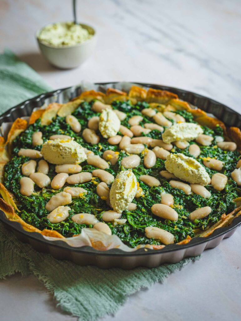 Torta salata patate e erbette su tavolo in marmo